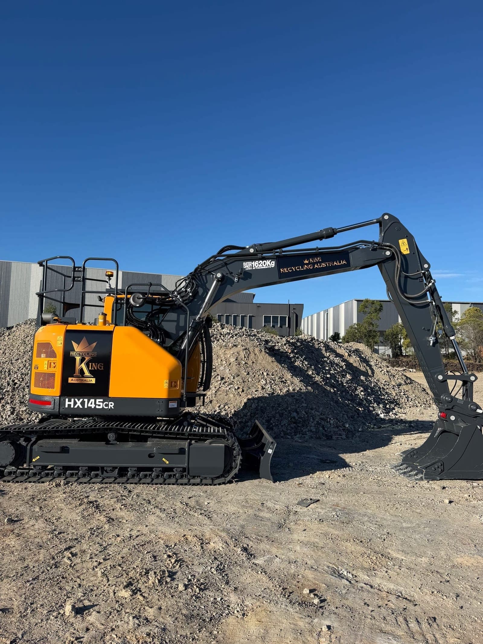 Hyundai HX145CR in Recycling King livery beside recycled aggregate stockpiles
