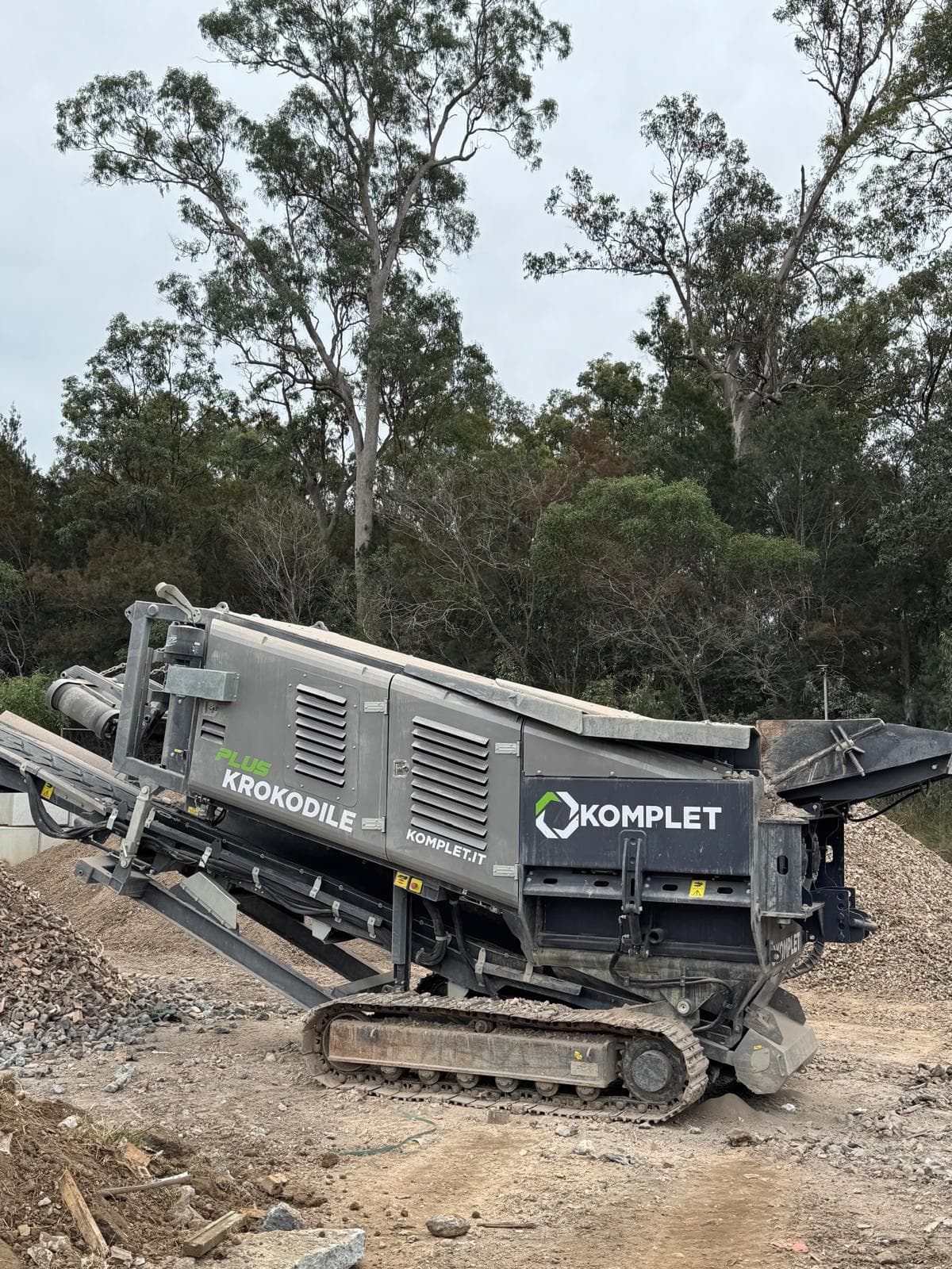 The Komplet Krokodile tracked shredder parked beside a stockpile of crushed material on a Queensland site