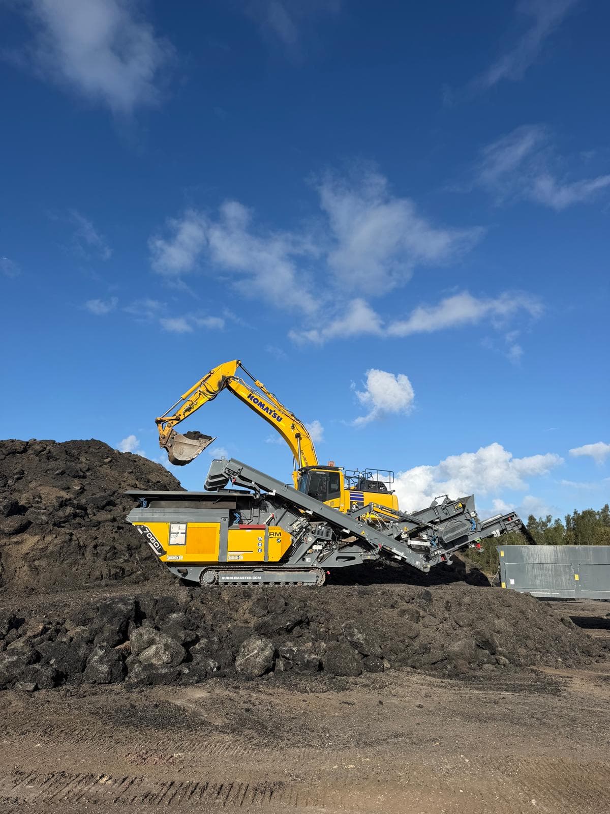 Excavator feeding demolition concrete into the RM 70GO! 2.0 mobile impact crusher on a Logan civil site