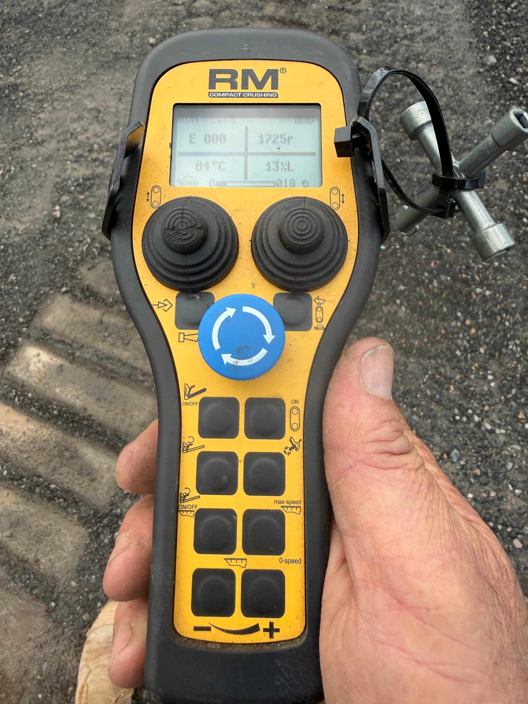 Operator holding the RM radio remote that runs the crusher, the control handed over on a dry hire