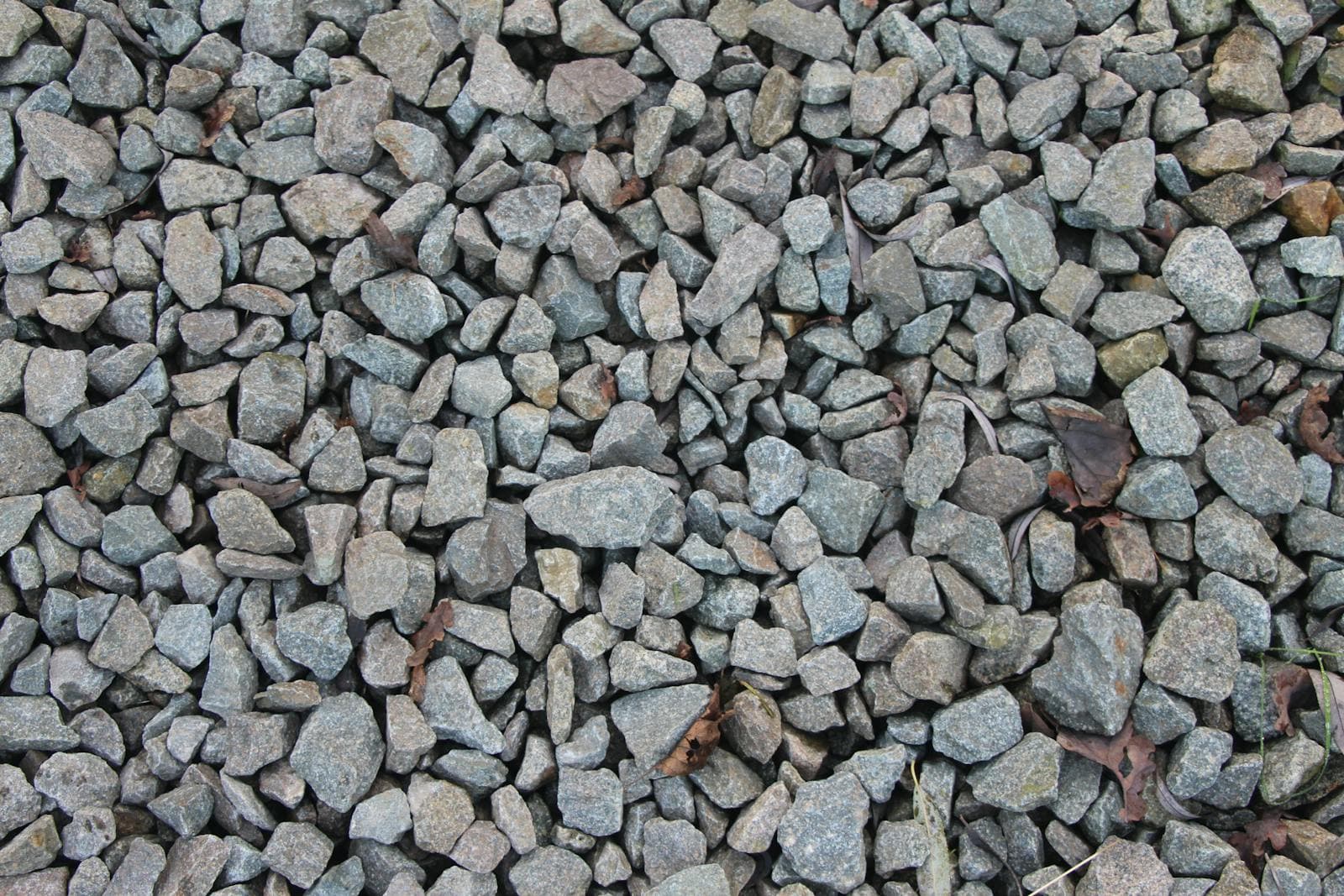 Close-up of grey angular quarried aggregate, the crushed rock road base that recycled crushed concrete is usually compared against